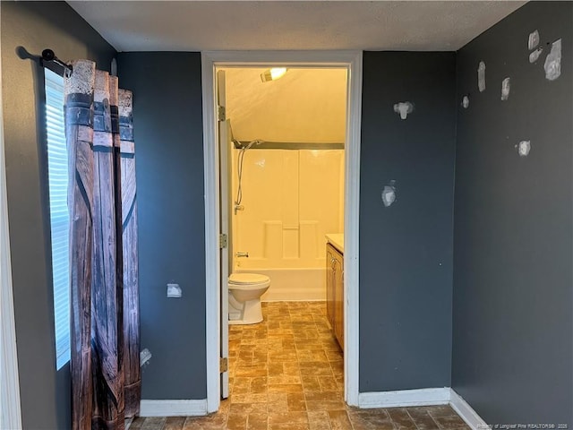 bathroom featuring  shower combination, toilet, and baseboards