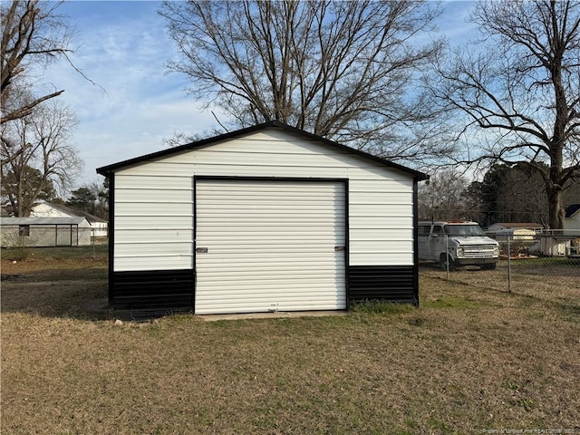 view of outbuilding featuring fence and an outbuilding