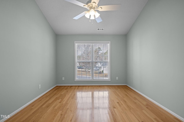 unfurnished room with light wood-style floors, baseboards, visible vents, and ceiling fan