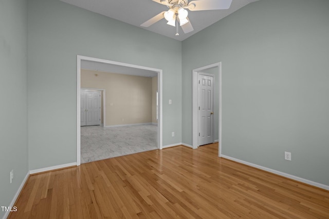 spare room featuring light wood-style floors, baseboards, and a ceiling fan