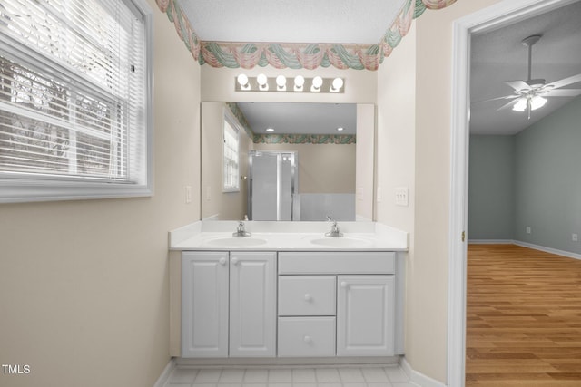 bathroom featuring double vanity, a sink, and a wealth of natural light