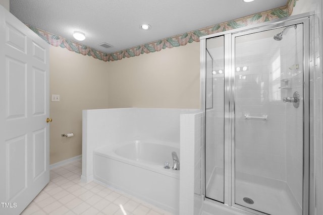 full bathroom featuring a garden tub, a stall shower, a textured ceiling, tile patterned flooring, and baseboards