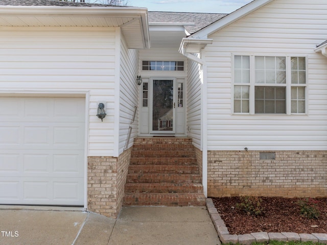 entrance to property featuring roof with shingles, crawl space, and an attached garage