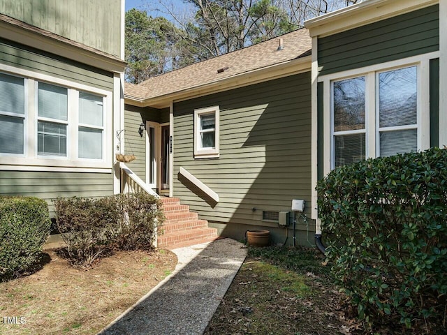 doorway to property with roof with shingles and crawl space