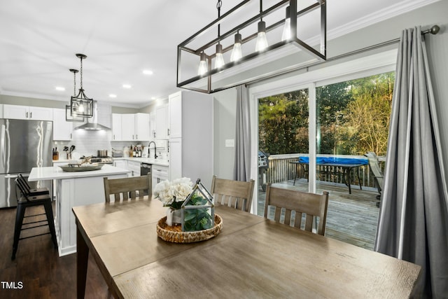 dining space with recessed lighting, dark wood-style flooring, and crown molding