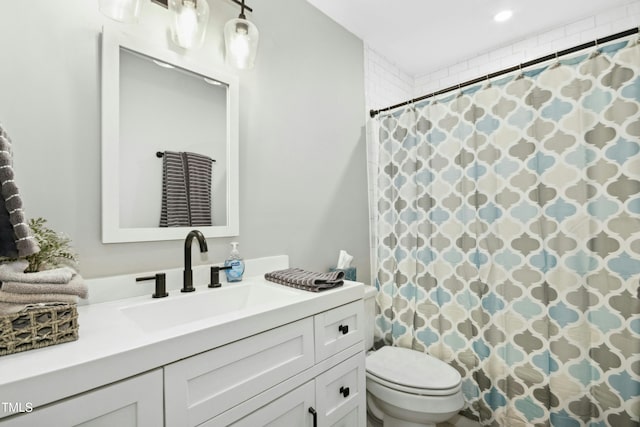 bathroom with curtained shower, vanity, and toilet