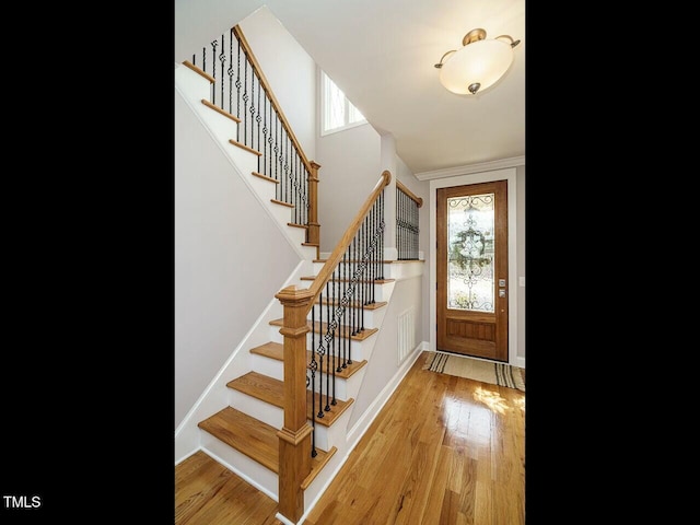 entryway featuring stairway, baseboards, and wood finished floors