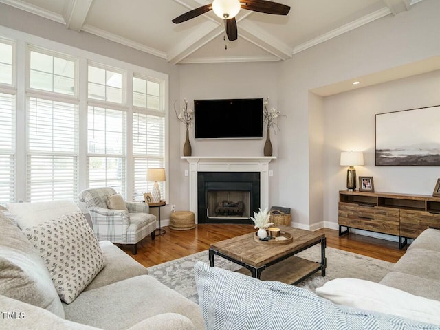 living area featuring a fireplace, baseboards, beam ceiling, and wood finished floors