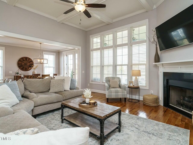 living room with beamed ceiling, a fireplace, wood finished floors, and crown molding