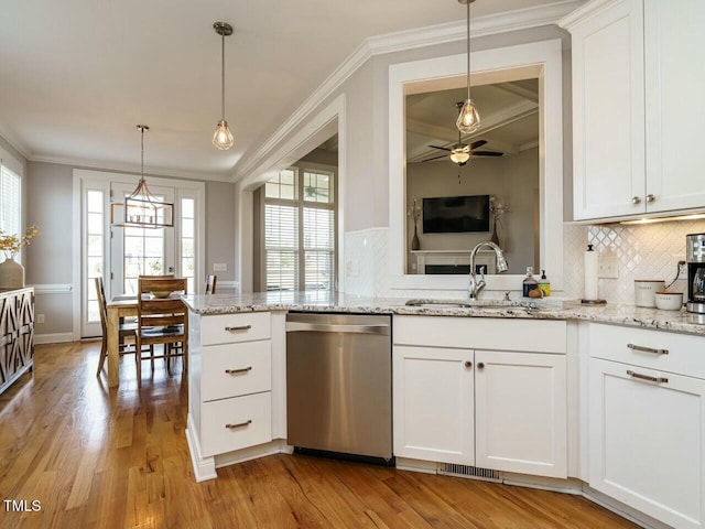 kitchen featuring ornamental molding, light wood-style floors, dishwasher, and a sink