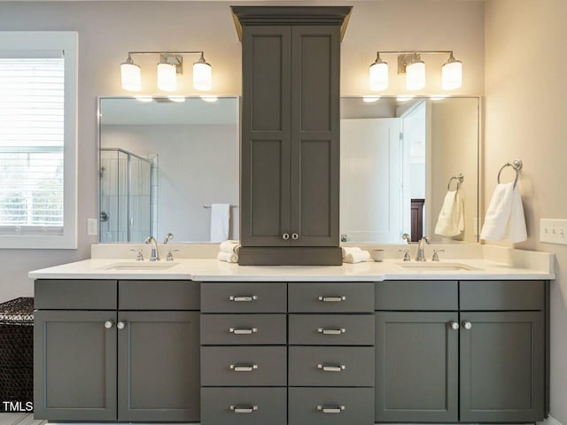 full bathroom with double vanity, a stall shower, and a sink