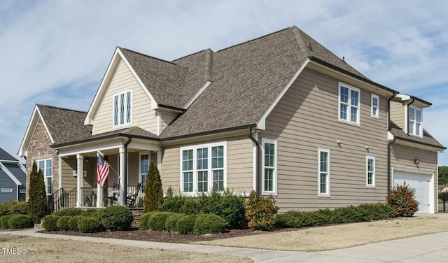 view of front of property featuring a shingled roof, covered porch, and an attached garage