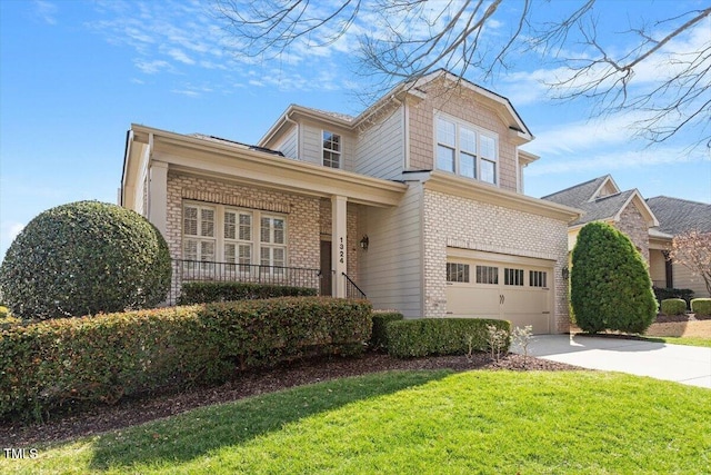 traditional-style house featuring a porch, a garage, brick siding, driveway, and a front lawn