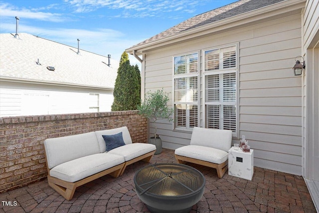 view of patio with an outdoor living space with a fire pit