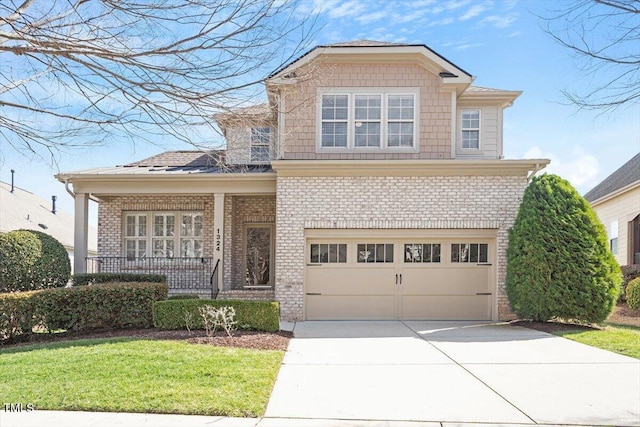 view of front facade with a garage, brick siding, concrete driveway, covered porch, and a front yard