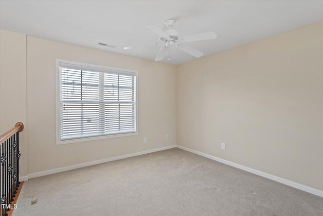 unfurnished room featuring carpet floors, a ceiling fan, visible vents, and baseboards