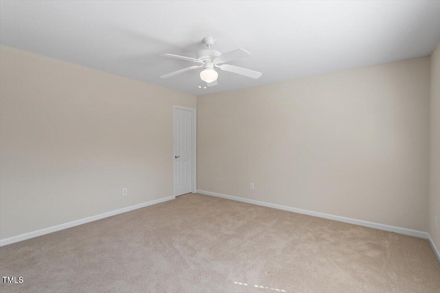 unfurnished room featuring light carpet, a ceiling fan, and baseboards