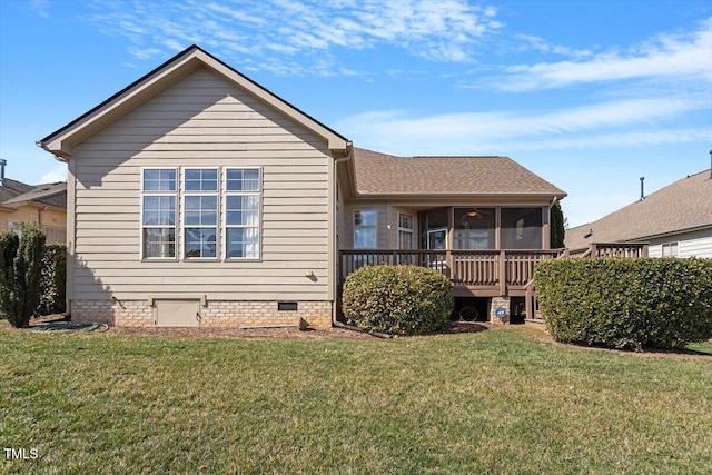 back of property with crawl space, a sunroom, a shingled roof, and a lawn