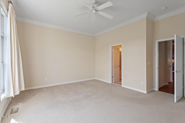 unfurnished bedroom with ornamental molding, light colored carpet, baseboards, and a ceiling fan