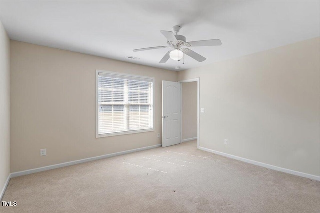 empty room featuring a ceiling fan, carpet, visible vents, and baseboards