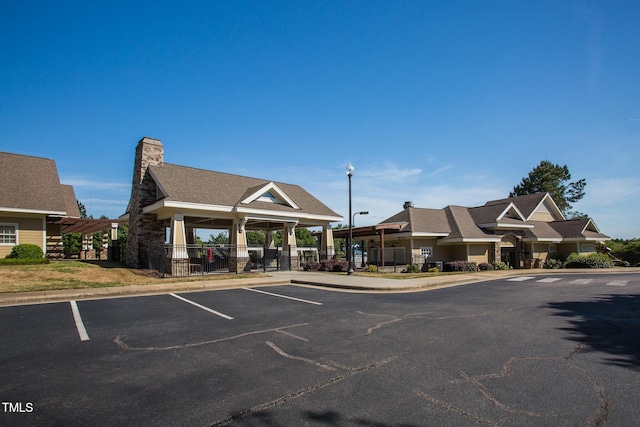 view of building exterior with uncovered parking and fence