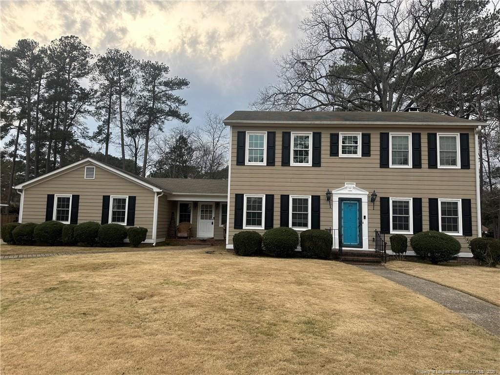 colonial house featuring a front lawn