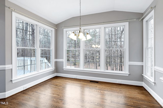 unfurnished dining area with visible vents, baseboards, vaulted ceiling, dark wood-type flooring, and a notable chandelier