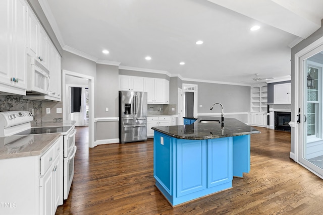 kitchen with dark wood-style floors, white appliances, ceiling fan, and a sink