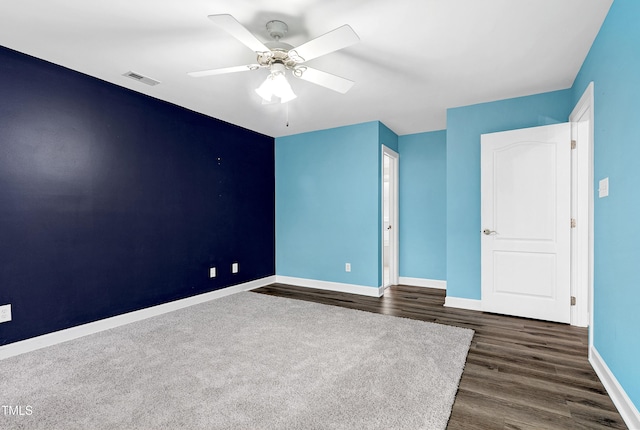 unfurnished bedroom with ceiling fan, dark wood-style floors, visible vents, and baseboards