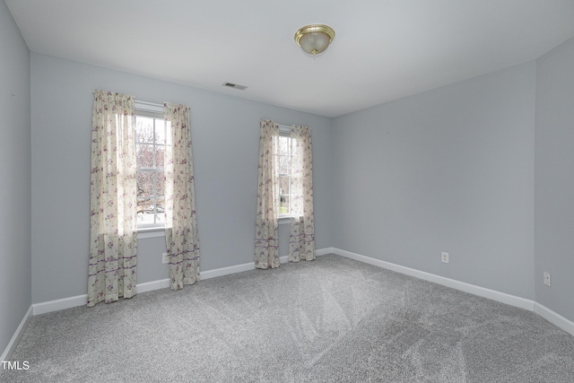 spare room with visible vents, baseboards, and carpet flooring