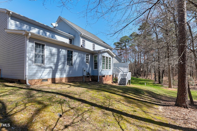 back of house featuring a lawn and crawl space