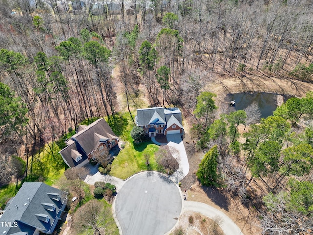 drone / aerial view featuring a wooded view