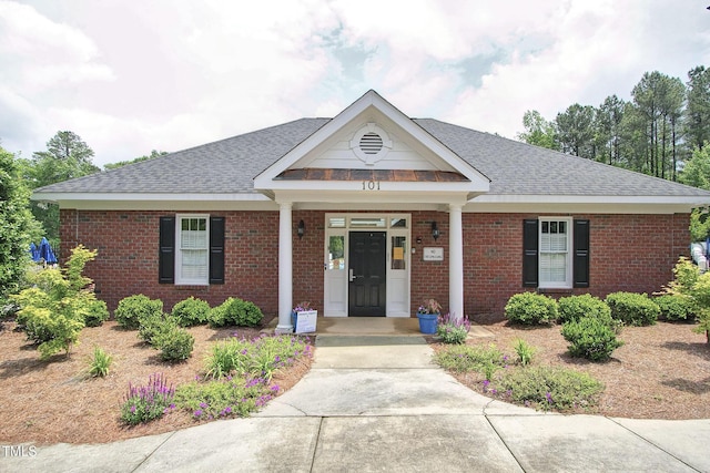 view of front of house with brick siding and a shingled roof