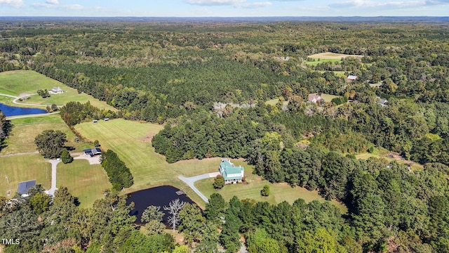 birds eye view of property featuring a water view and a view of trees