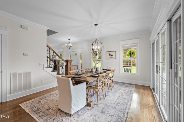 dining area featuring a chandelier, wood finished floors, visible vents, and crown molding