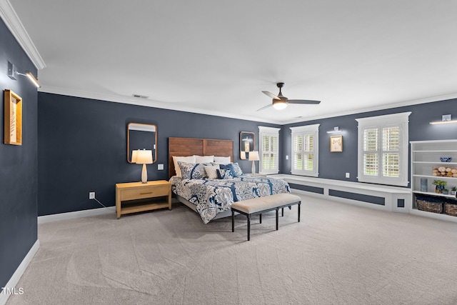 carpeted bedroom with visible vents, ornamental molding, a ceiling fan, and baseboards