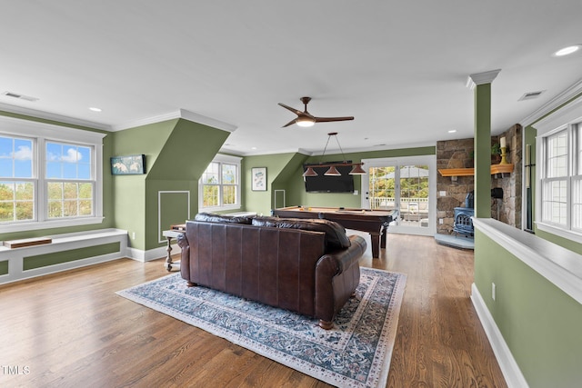 living area featuring visible vents, wood finished floors, and ornamental molding