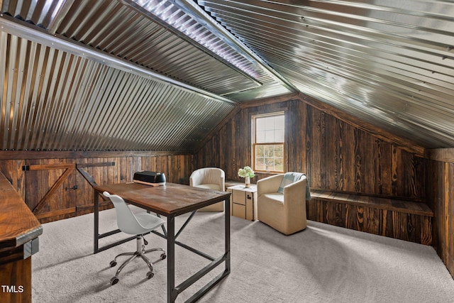 office with wood walls, vaulted ceiling, and light colored carpet
