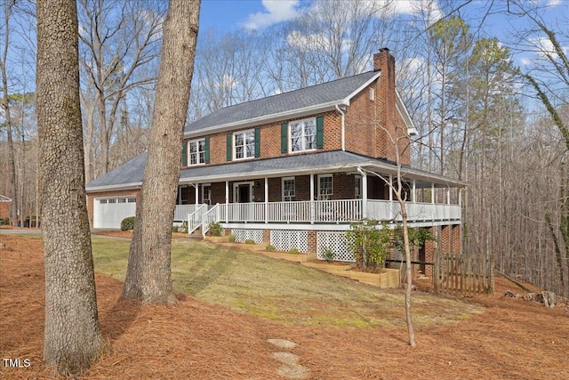 view of front facade with brick siding, a chimney, covered porch, an attached garage, and a front yard