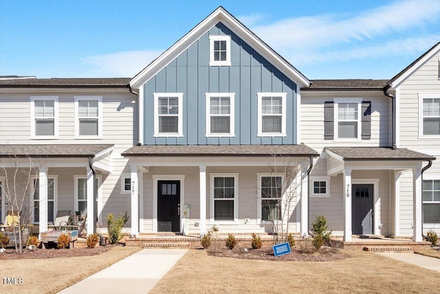 townhome / multi-family property featuring covered porch, roof with shingles, and board and batten siding