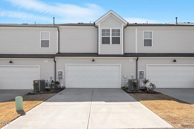 view of front facade with a garage, cooling unit, and concrete driveway