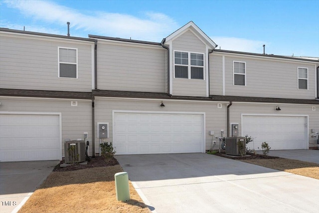 view of front of house with a garage, concrete driveway, and central air condition unit