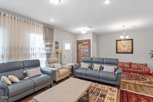 living room with wood finished floors and an inviting chandelier