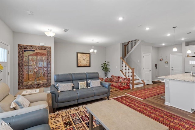 living area featuring recessed lighting, wood finished floors, visible vents, baseboards, and stairway