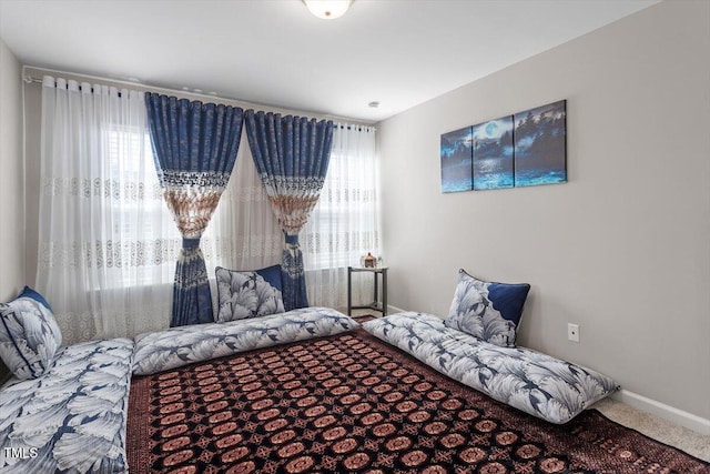 carpeted bedroom with multiple windows and baseboards