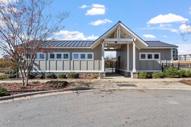 view of front of home featuring an attached carport, a standing seam roof, metal roof, and concrete driveway