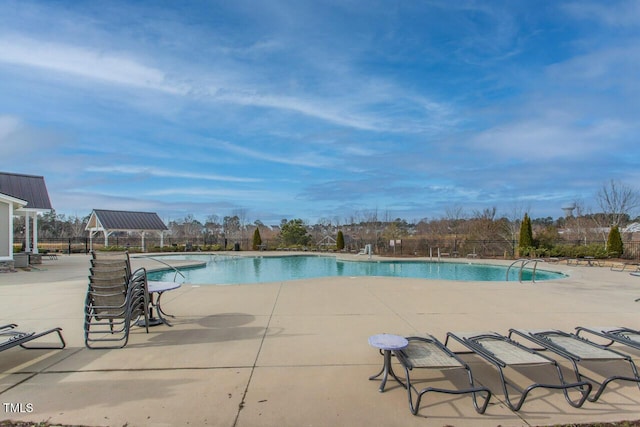 community pool featuring a patio area and fence