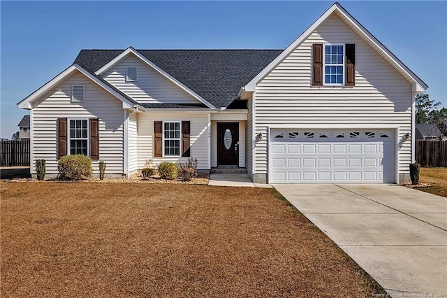 traditional-style house with a shingled roof, fence, a front lawn, and concrete driveway