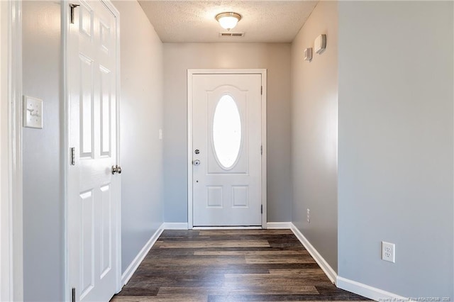 entryway featuring dark wood-style floors, baseboards, visible vents, and a textured ceiling