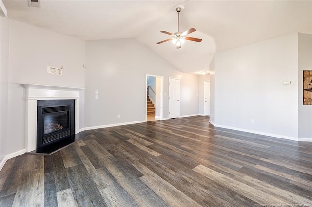 unfurnished living room with baseboards, wood finished floors, and a glass covered fireplace